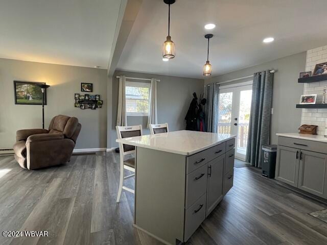 kitchen with a breakfast bar, a kitchen island, hanging light fixtures, and a wealth of natural light