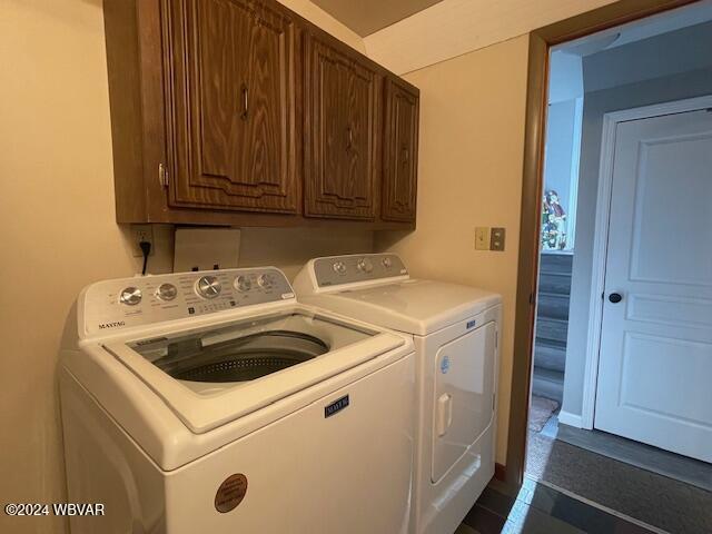 laundry room with washer and dryer and cabinets