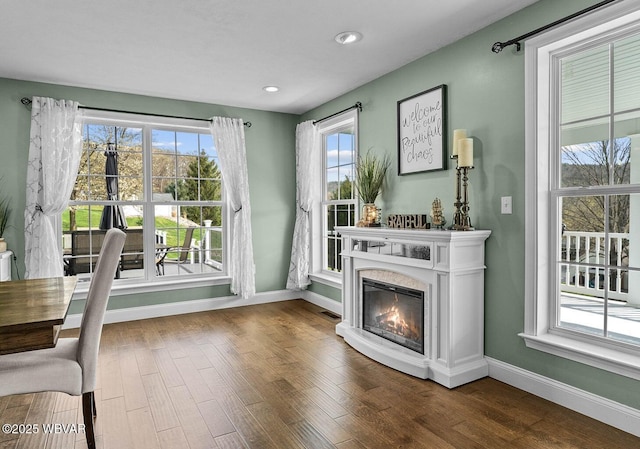 sitting room with baseboards, wood finished floors, a fireplace, and recessed lighting