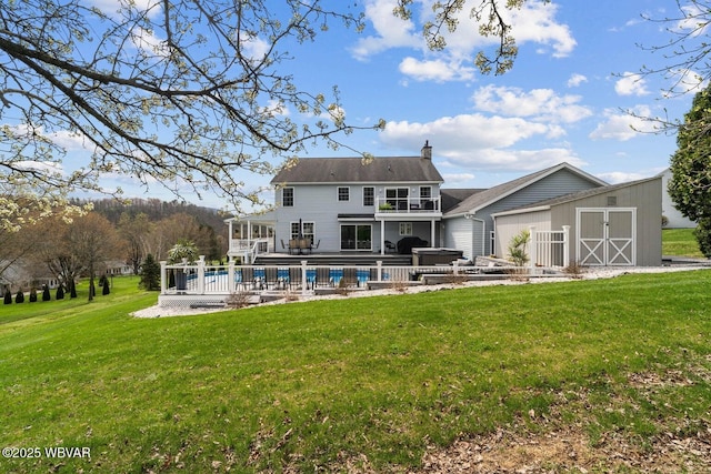 rear view of house featuring a balcony, a chimney, a swimming pool, and a yard