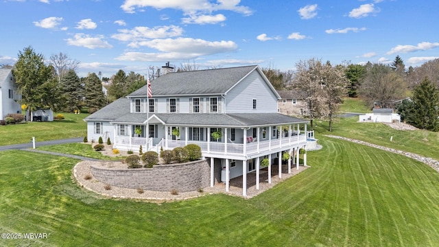 rear view of house featuring a chimney, a lawn, and a shingled roof