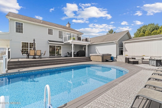 swimming pool with a hot tub, a wooden deck, and an outdoor hangout area