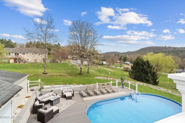 swimming pool with an outdoor hangout area, a yard, and a mountain view