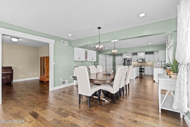 dining area with a chandelier, dark wood-style floors, recessed lighting, and baseboards