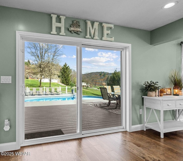 doorway to outside with baseboards, wood finished floors, and recessed lighting
