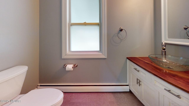 bathroom featuring vanity, a baseboard heating unit, and toilet