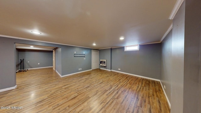 basement featuring crown molding, light hardwood / wood-style floors, and heating unit