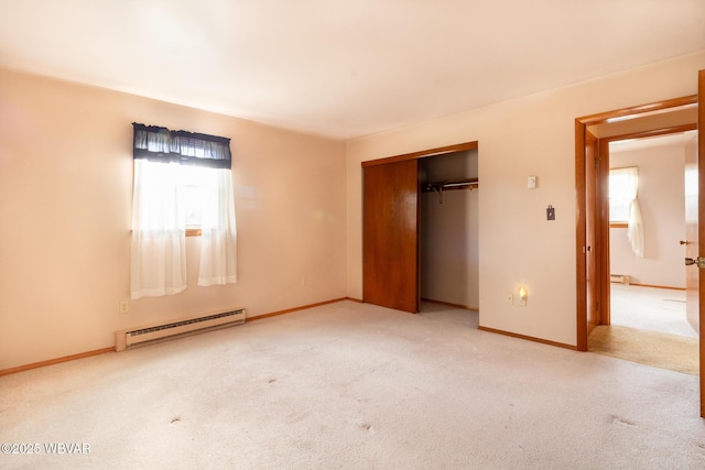 unfurnished bedroom with baseboard heating, multiple windows, a closet, and light colored carpet