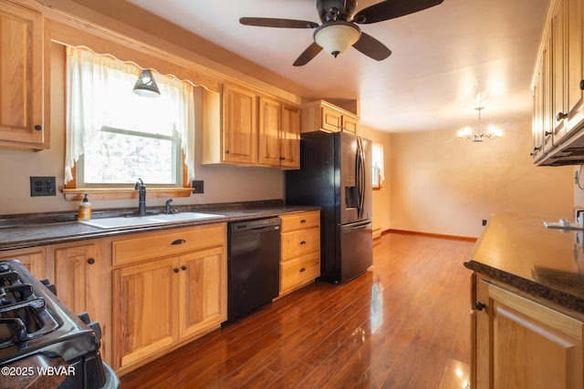 kitchen with dark wood-type flooring, black appliances, ceiling fan with notable chandelier, sink, and decorative light fixtures