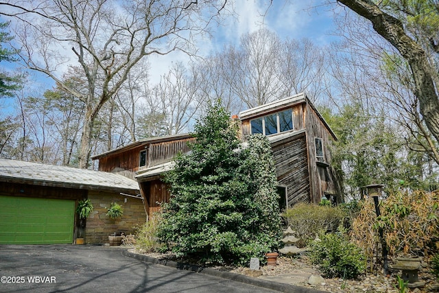 view of side of property with an attached garage and driveway