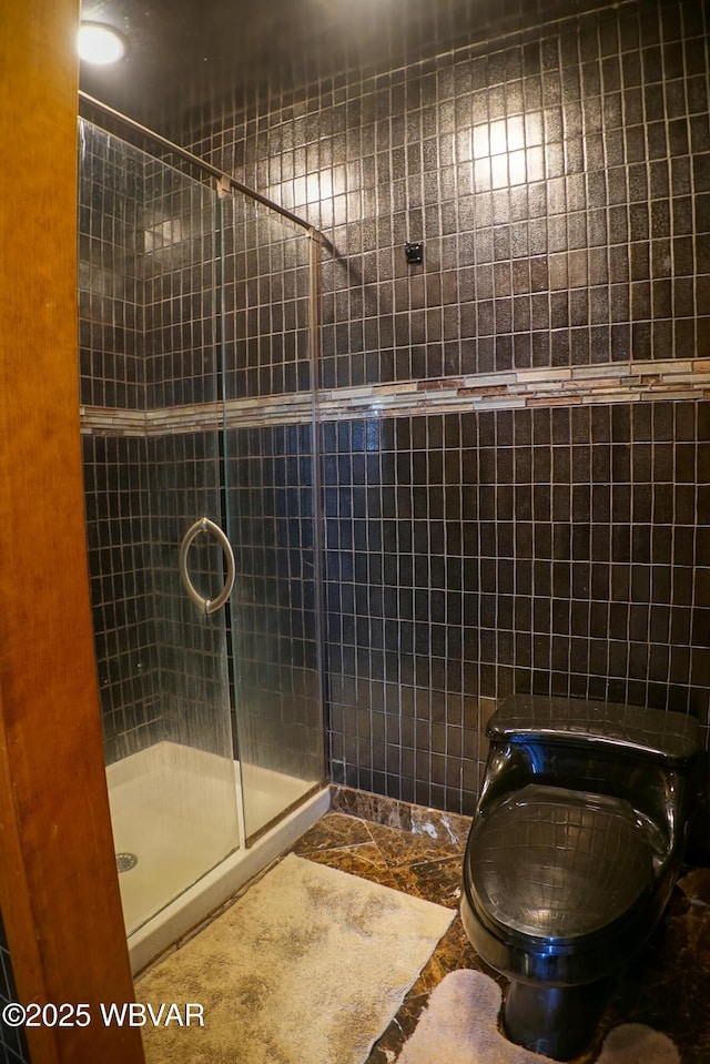 full bath with a shower stall, marble finish floor, and toilet