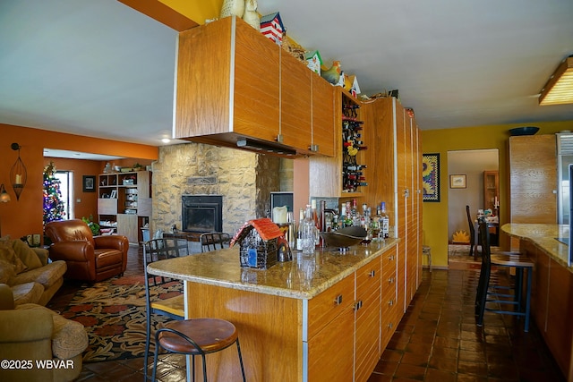 kitchen featuring open floor plan, a kitchen breakfast bar, and dark tile patterned flooring