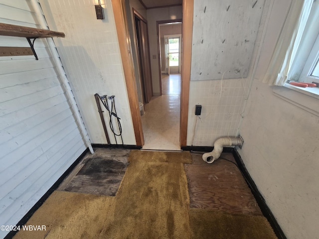 corridor with carpet flooring and tile walls