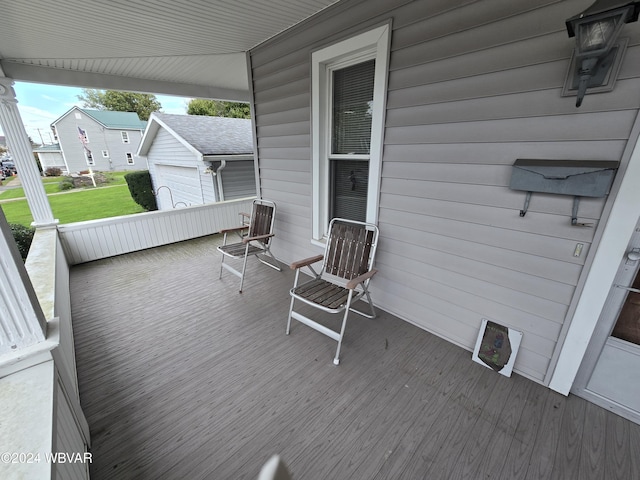 wooden terrace with covered porch and a garage