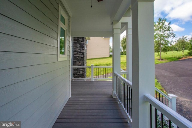 wooden deck featuring a lawn