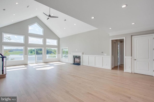 unfurnished living room featuring high vaulted ceiling, light hardwood / wood-style floors, and ceiling fan