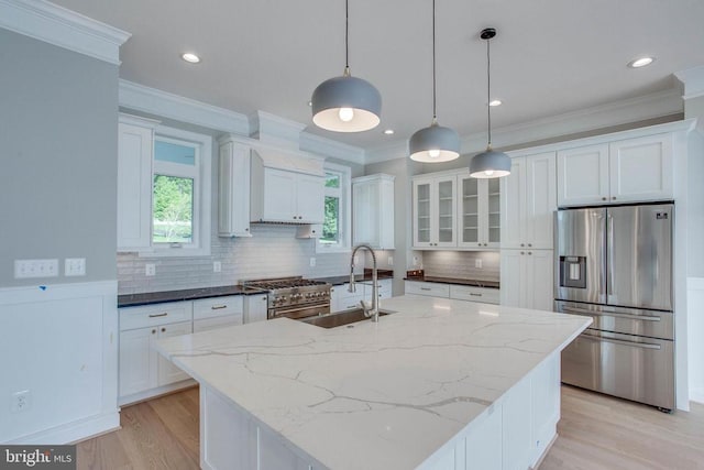 kitchen with decorative light fixtures, white cabinetry, stainless steel appliances, and sink