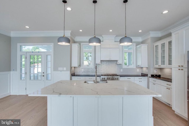 kitchen featuring white cabinetry, light hardwood / wood-style floors, and decorative light fixtures