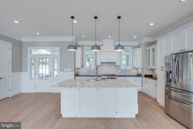 kitchen with stainless steel fridge, white cabinets, and light wood-type flooring