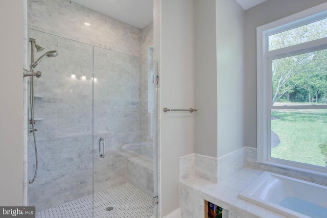 bathroom featuring plenty of natural light and shower with separate bathtub