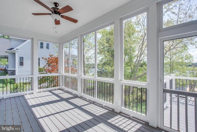 unfurnished sunroom featuring ceiling fan and a healthy amount of sunlight