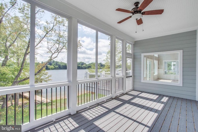 unfurnished sunroom with a water view and ceiling fan