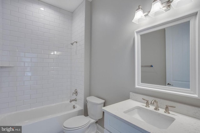 full bathroom featuring tiled shower / bath, toilet, and vanity