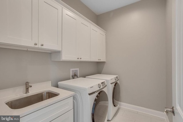 laundry area featuring sink, hookup for a washing machine, light tile flooring, cabinets, and washer and dryer