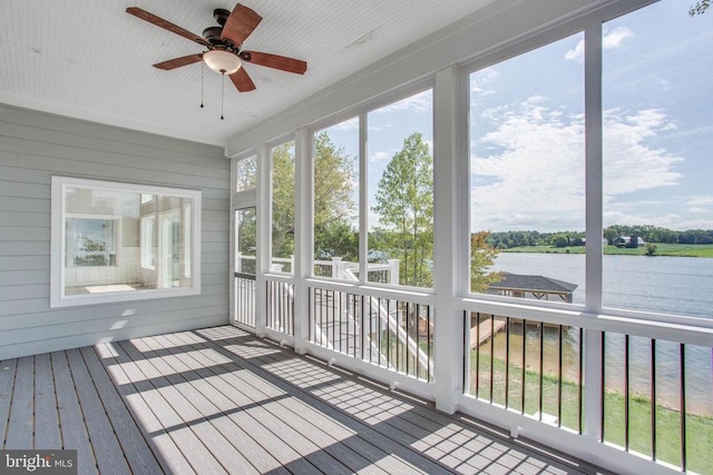 unfurnished sunroom with a water view and ceiling fan