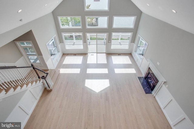 living room with high vaulted ceiling and light hardwood / wood-style floors