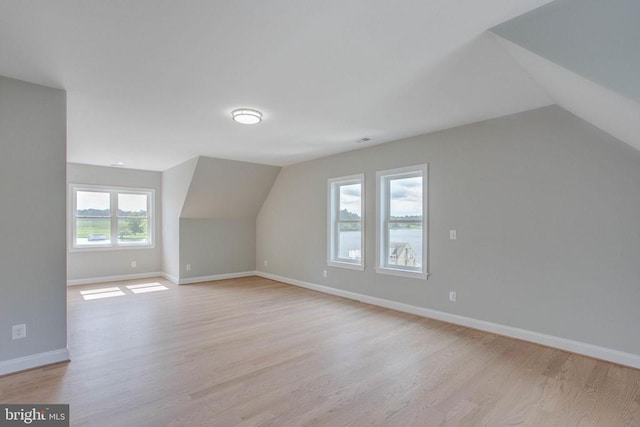 additional living space with lofted ceiling and light hardwood / wood-style flooring