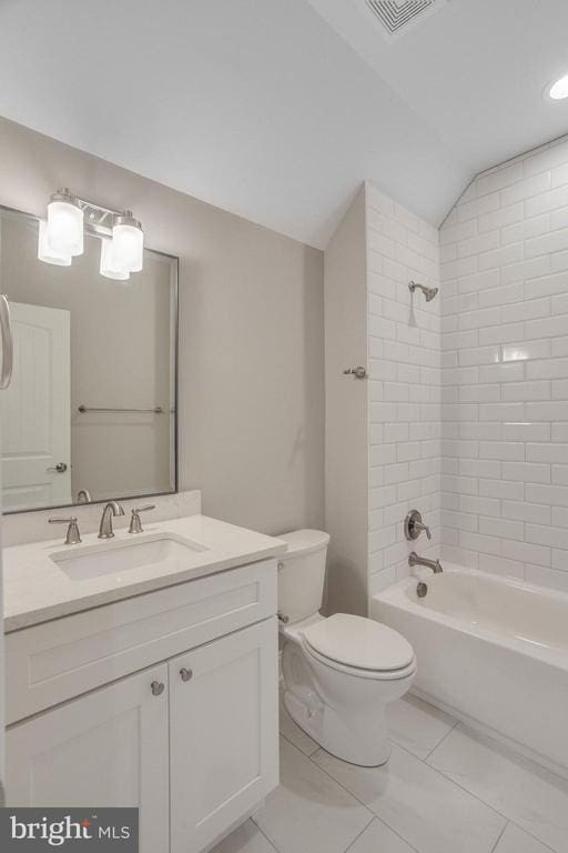 full bathroom with toilet, tiled shower / bath, vanity, lofted ceiling, and tile floors