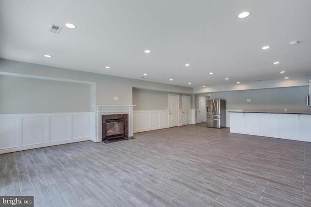 unfurnished living room featuring a high end fireplace and light hardwood / wood-style flooring