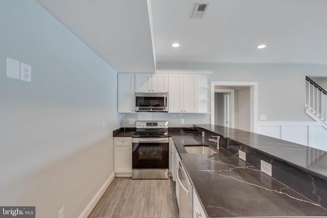 kitchen featuring white cabinetry, stainless steel appliances, sink, and light wood-type flooring