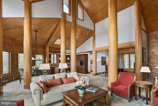 living room with a chandelier, wooden walls, wooden ceiling, and high vaulted ceiling