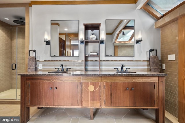 bathroom with double vanity, tile flooring, vaulted ceiling with skylight, and walk in shower