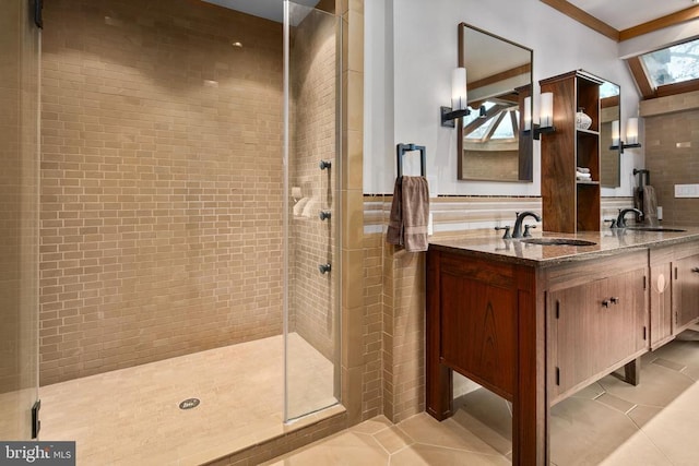 bathroom featuring a skylight, crown molding, dual vanity, tile flooring, and a shower with shower door