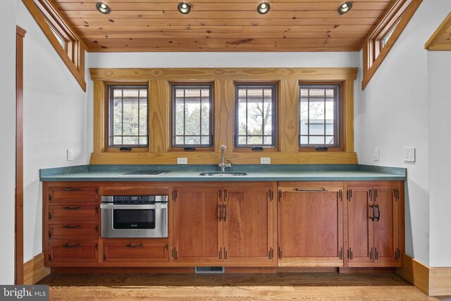 bar with wood ceiling, sink, oven, and light wood-type flooring