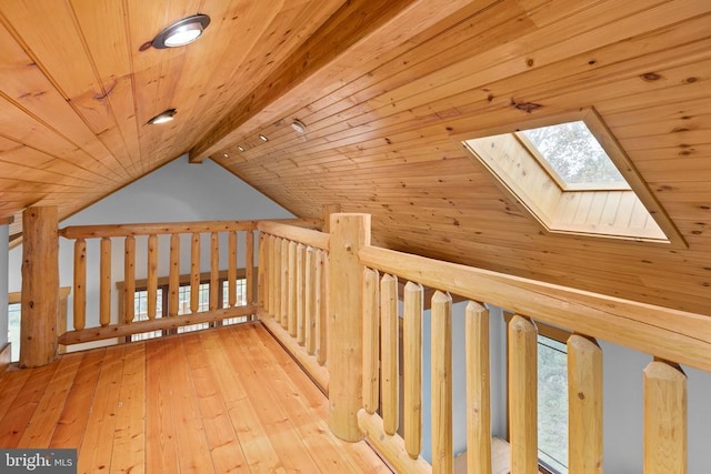 additional living space with vaulted ceiling with skylight, light wood-type flooring, and wooden ceiling