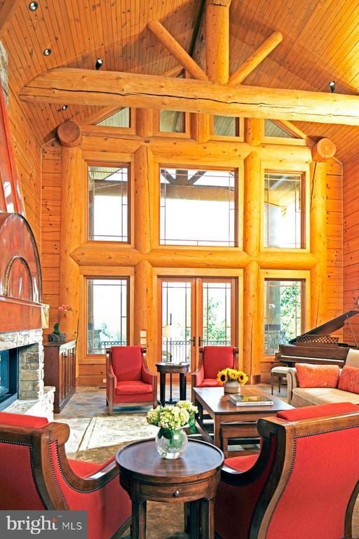 interior space featuring wood ceiling, high vaulted ceiling, french doors, and a fireplace