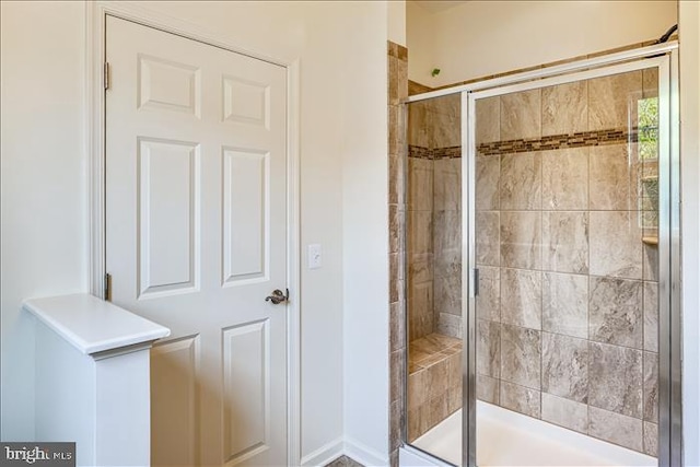 bathroom with a shower with door