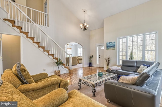 living room featuring high vaulted ceiling, a chandelier, and light hardwood / wood-style floors