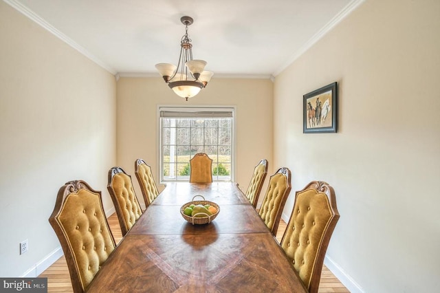 dining room featuring a notable chandelier, light hardwood / wood-style floors, and ornamental molding