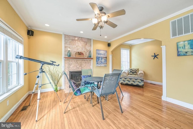 dining area featuring a fireplace, plenty of natural light, light hardwood / wood-style floors, and ceiling fan