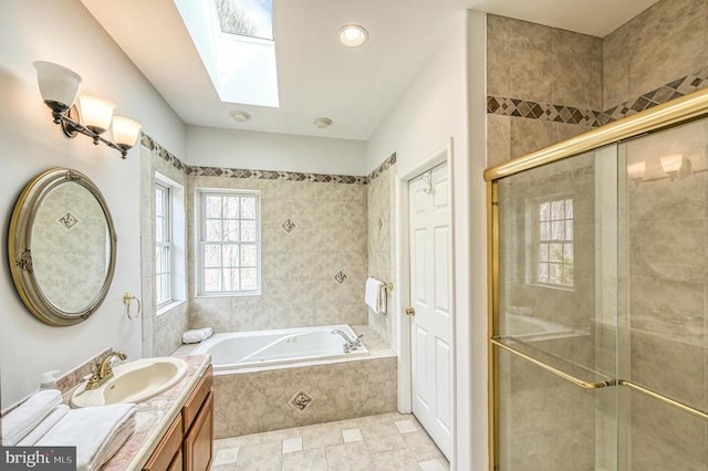 bathroom with independent shower and bath, vanity, tile floors, and a skylight