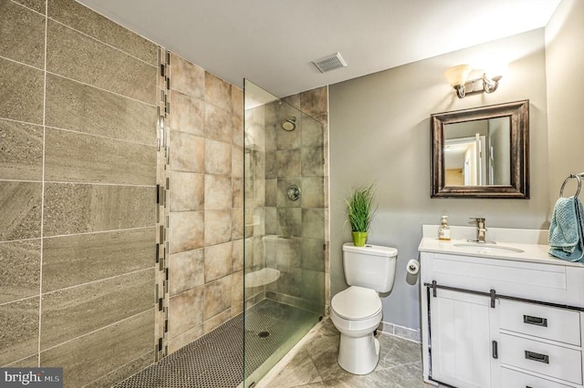 bathroom with an enclosed shower, toilet, tile floors, and vanity with extensive cabinet space