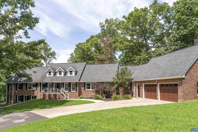 cape cod house featuring a front lawn and a garage