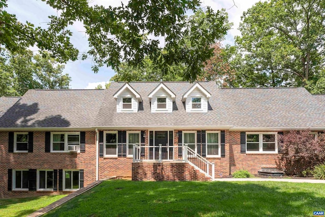 cape cod home featuring cooling unit and a front yard