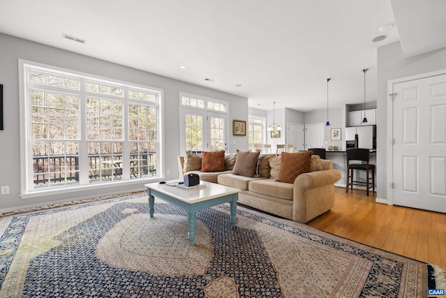 living area featuring visible vents, baseboards, and wood finished floors