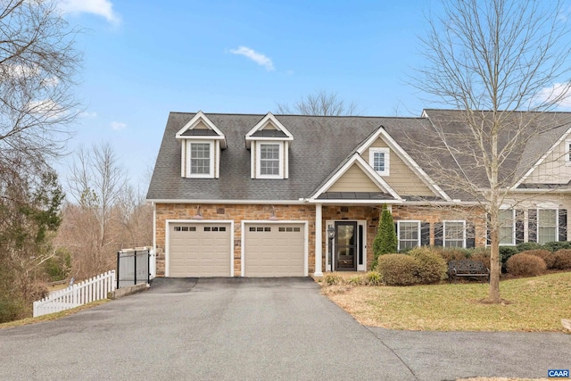 view of front of house featuring a front lawn, driveway, stone siding, fence, and a garage